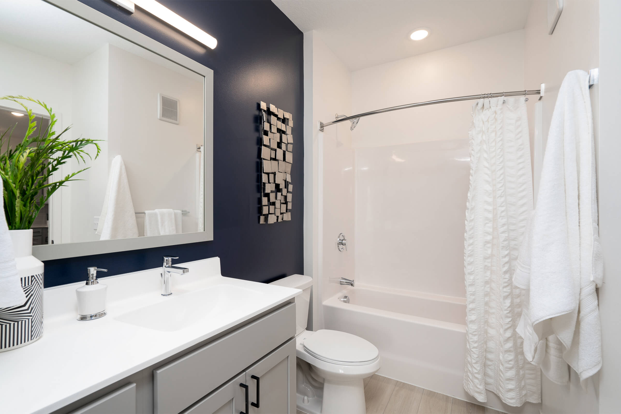 Bathroom with navy accent wall and white vanity