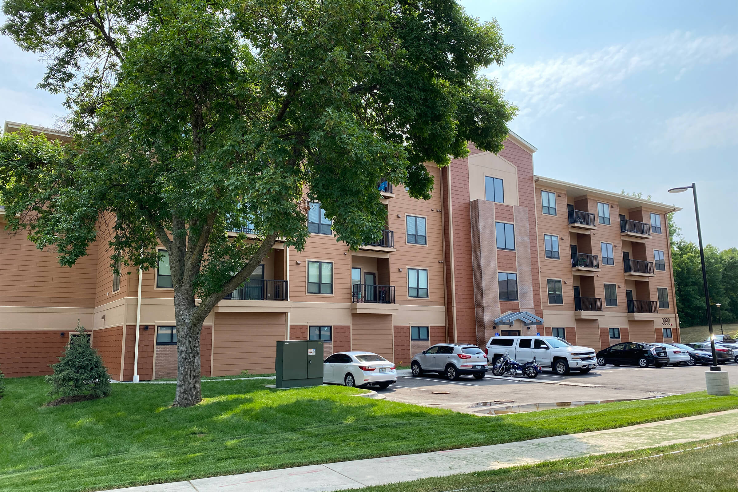 Exterior view of Ballantrae Apartments with trees and parking lot
