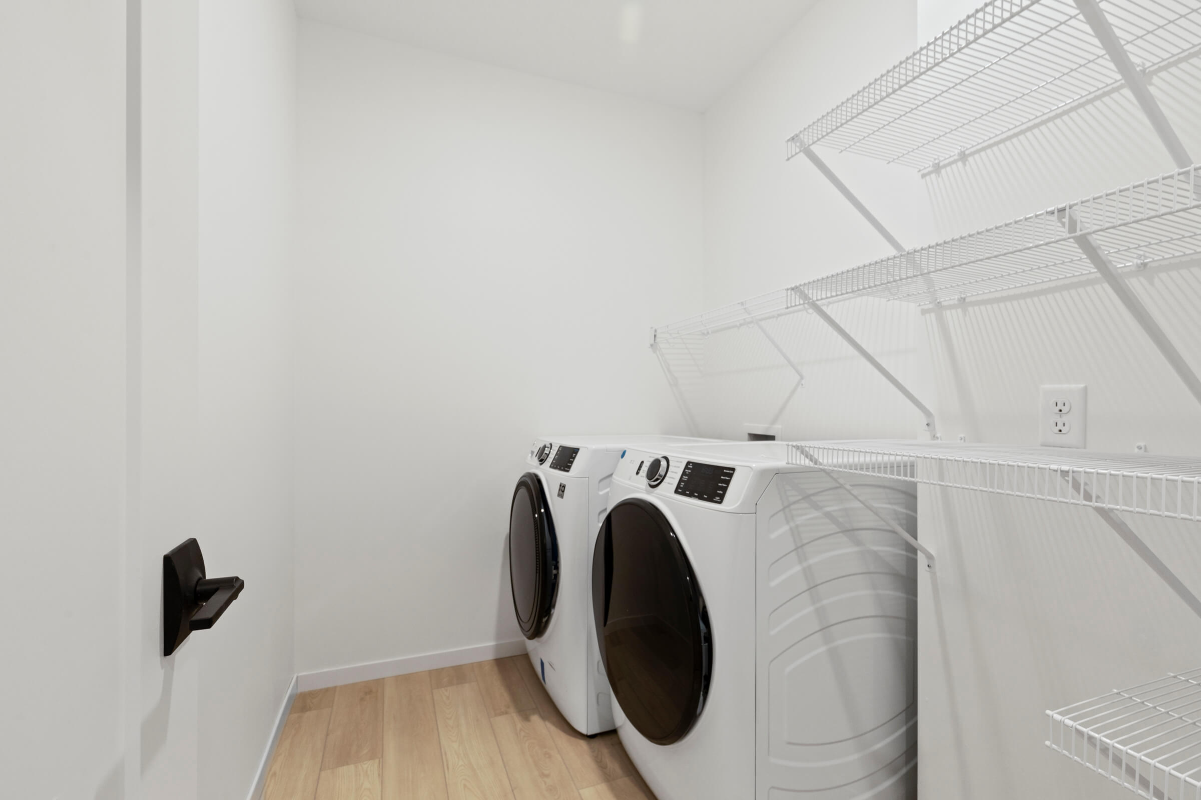 Laundry room with washer, dryer, and wire shelving