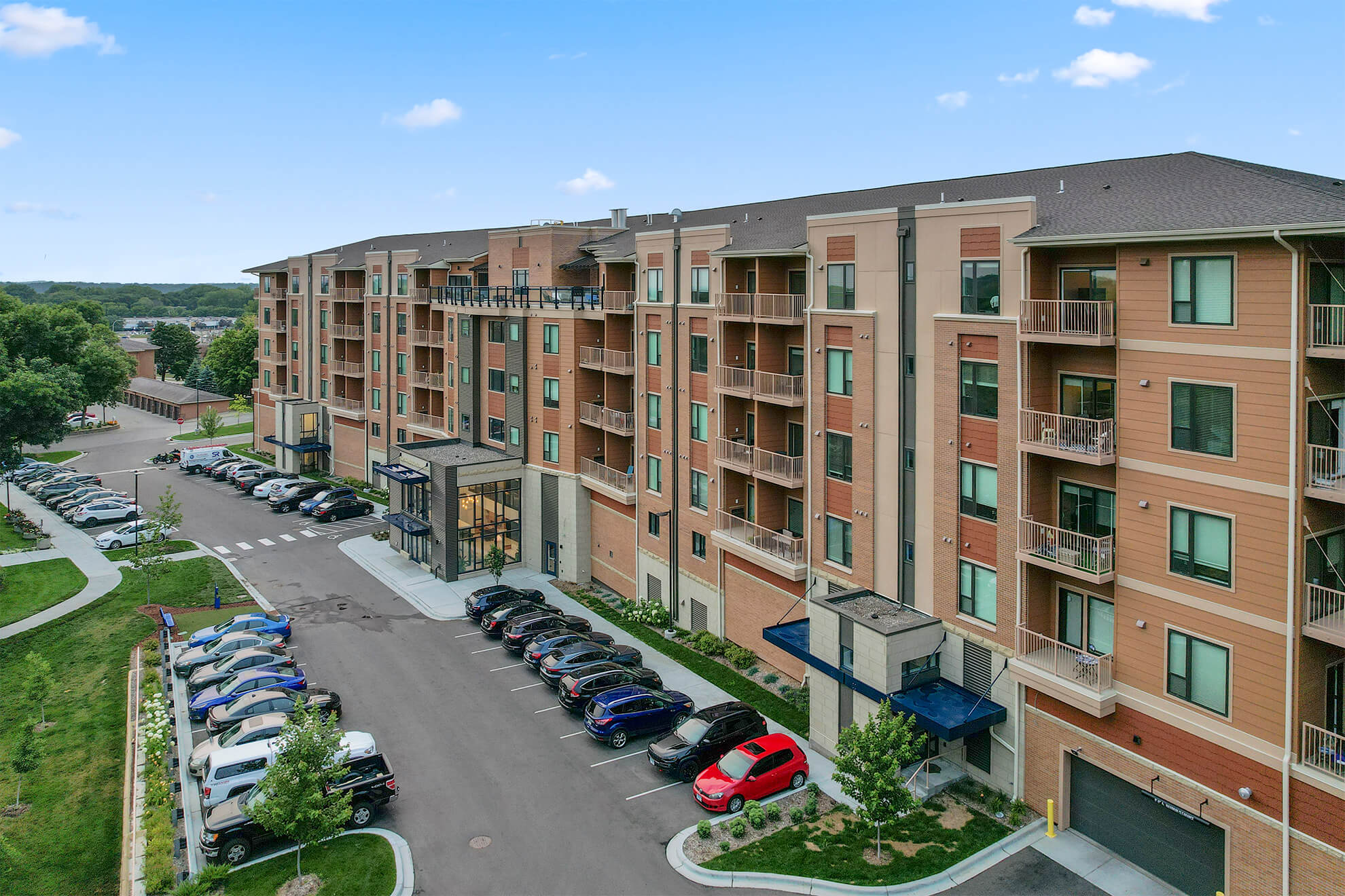 Angled view of Ballantrae Apartments showing main entrance, balconies, and parking lot