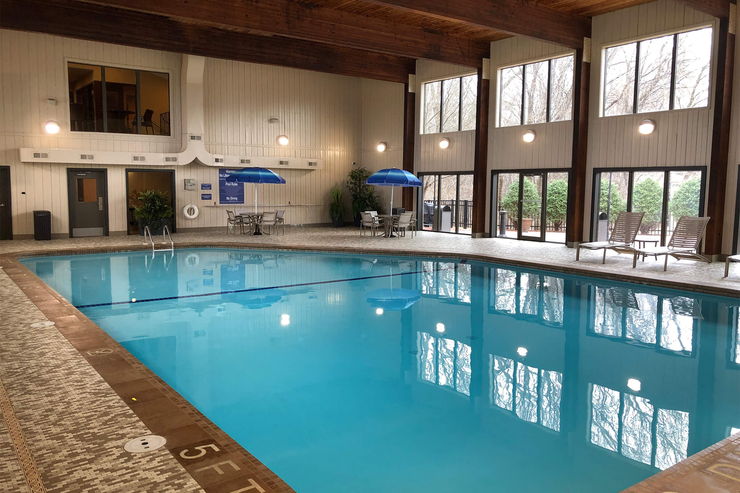 Indoor swimming pool with lounge chairs and umbrellas