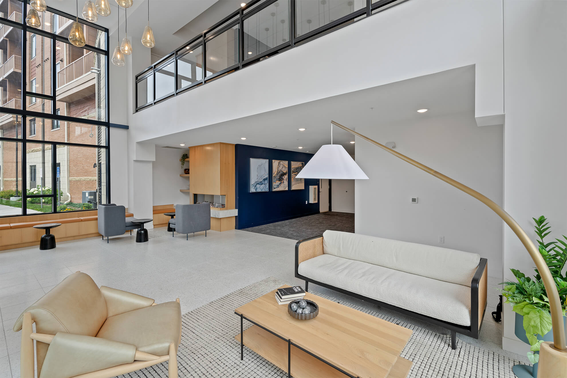 Stylish lobby seating area with modern furniture and tall windows at Ballantrae Apartments