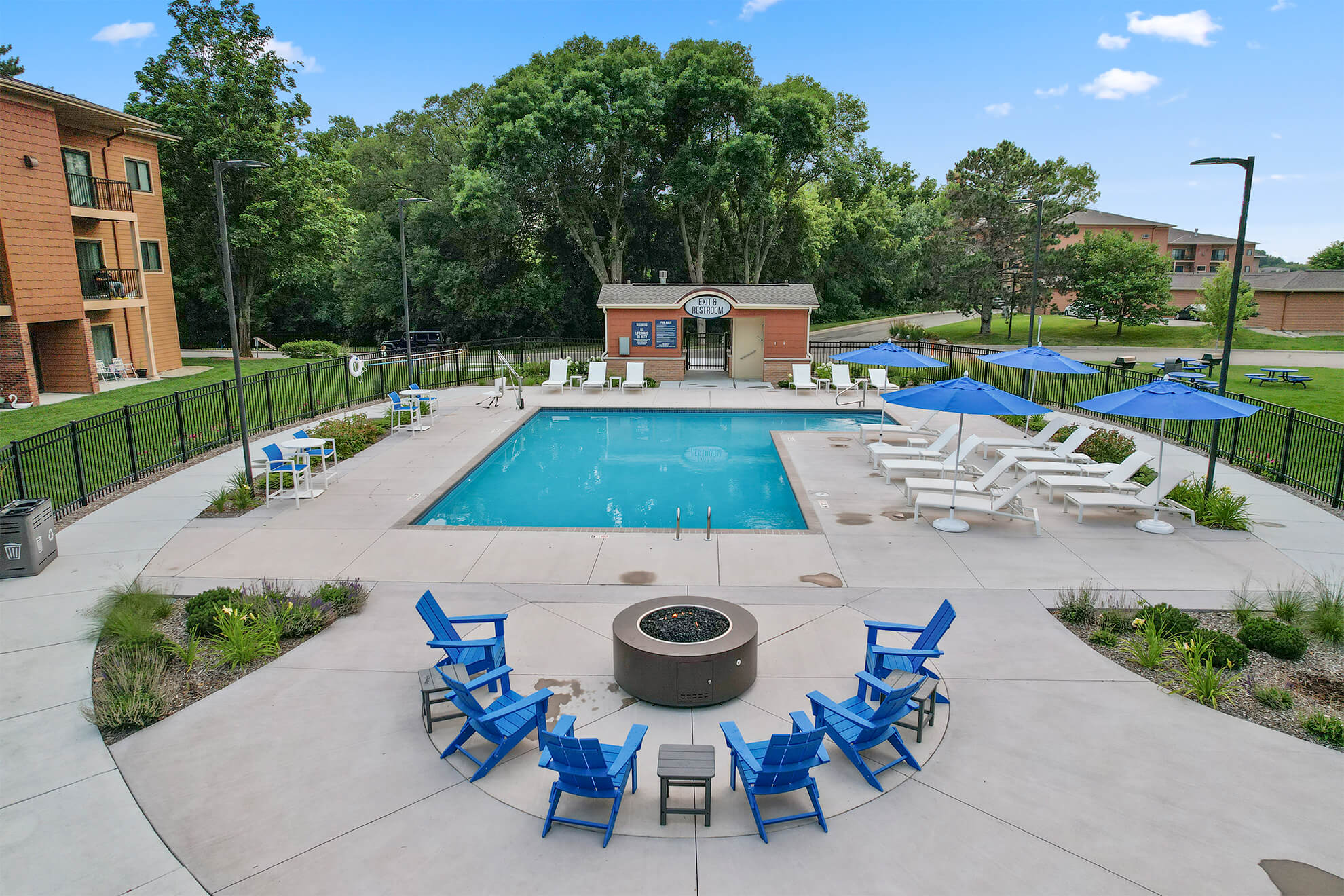 View of pool and firepit lounge with seating and umbrellas