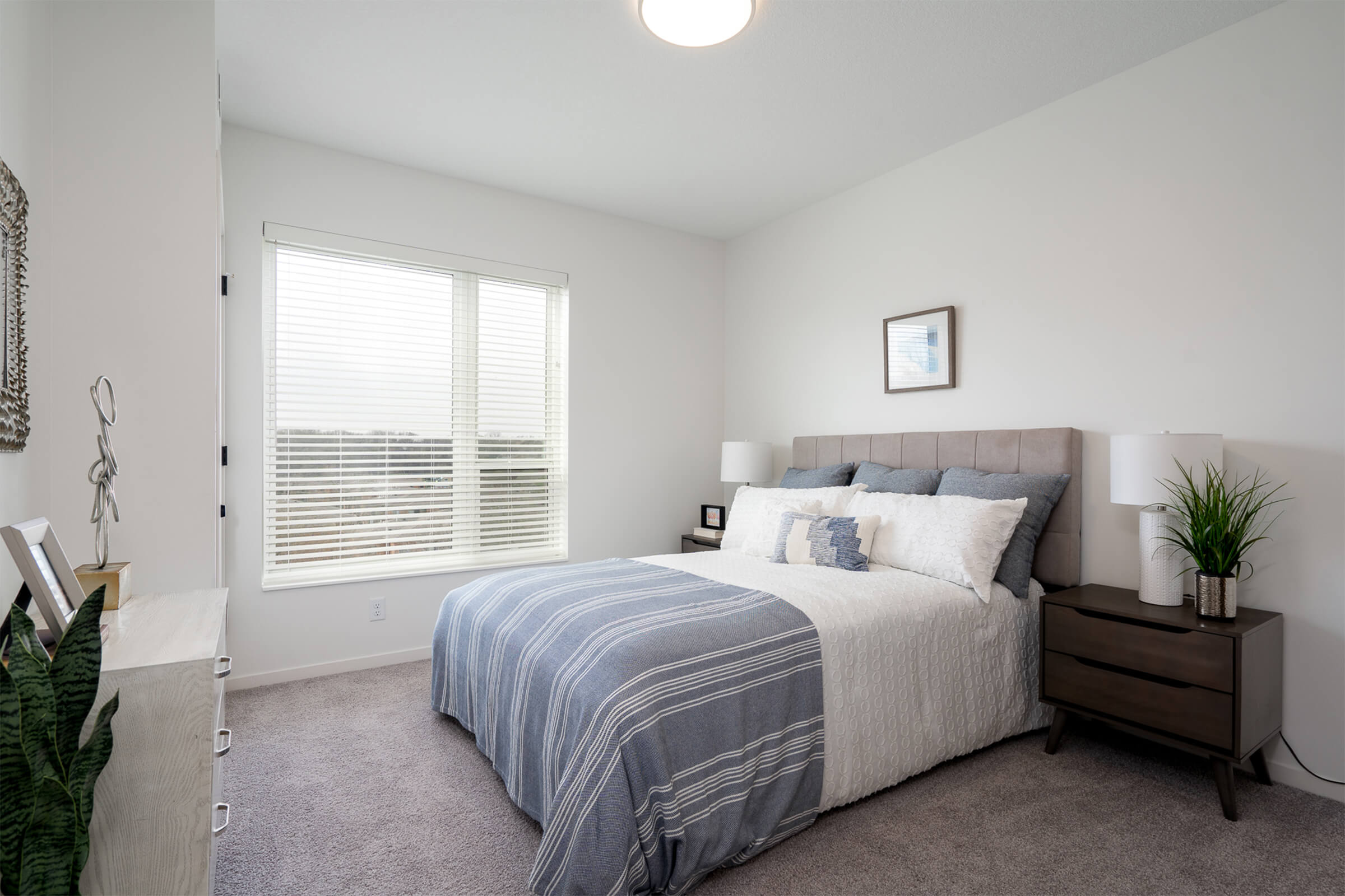 Bedroom with striped bedding and large window