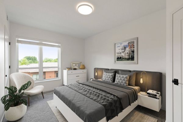 Staged bedroom with gray bedding and window view
