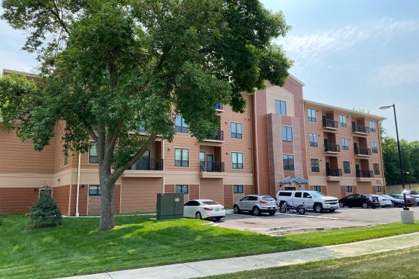 Exterior view of Ballantrae Apartments with trees and parking lot