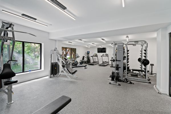 Modern apartment gym with treadmills, elliptical machines, and strength training equipment
