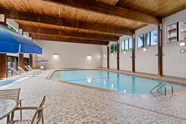 Indoor pool with patio tables and blue umbrellas