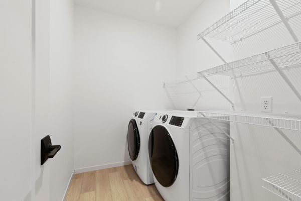 Laundry room with washer, dryer, and wire shelving