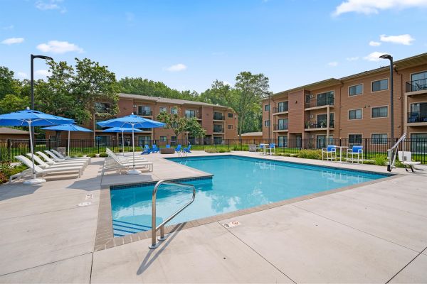 Deck view of the pool surrounded by lounge chairs and umbrellas