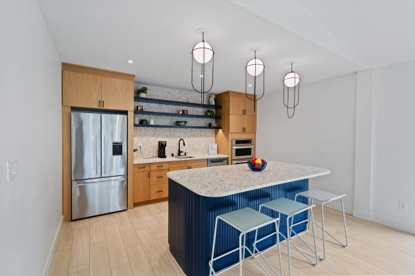 Community kitchen with center island, modern appliances, and pendant lighting
