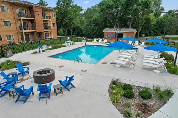 Outdoor firepit and pool area with cozy seating and trees